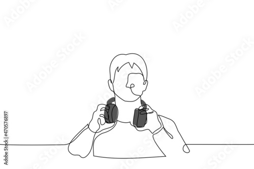 man has taken off overhead headphones from  ears and listens attentively to extraneous noise or is distracted and he is listening to speaker - one line drawing vector. concept to interrupt listening