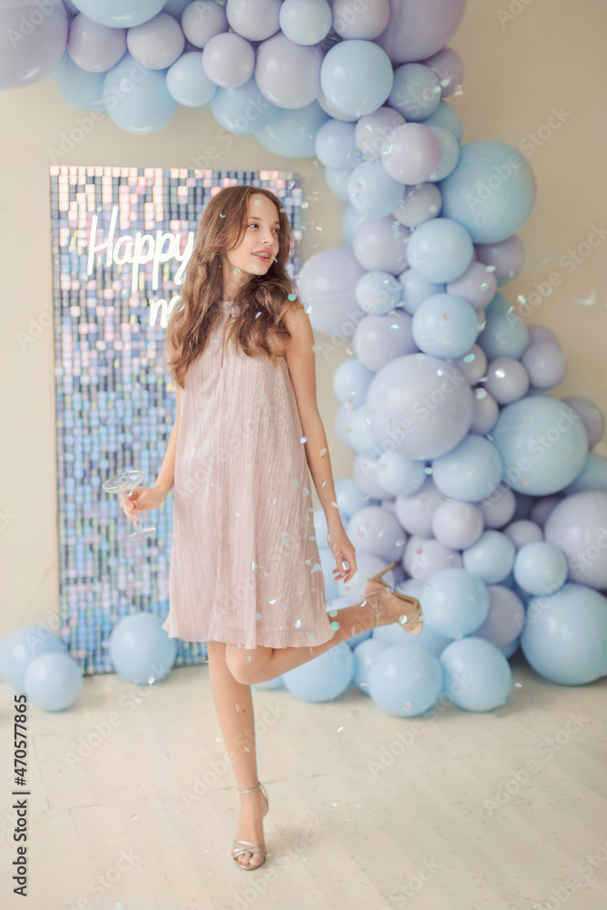 Fototapeta premium girl in a beautiful dress against the background of New Year's decorations from balls