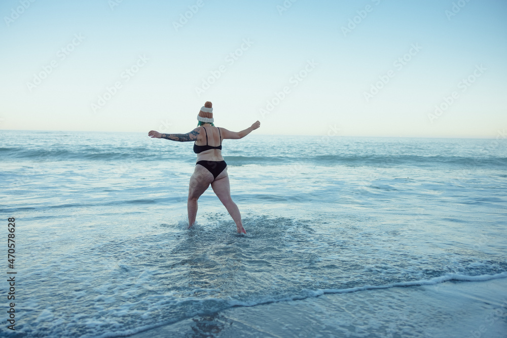 Woman enjoying the cold sea water at the beach