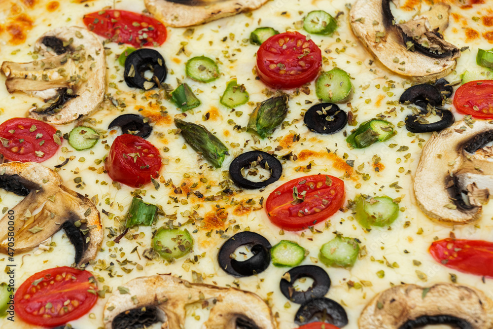 Close-up of vegetarian pizza with mushrooms, cheese, black olives and tomatoes cherry.