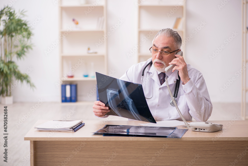 Old male doctor radiologist working in the clinic during pandemi Old male doctor radiologist working in the clinic during pandemi