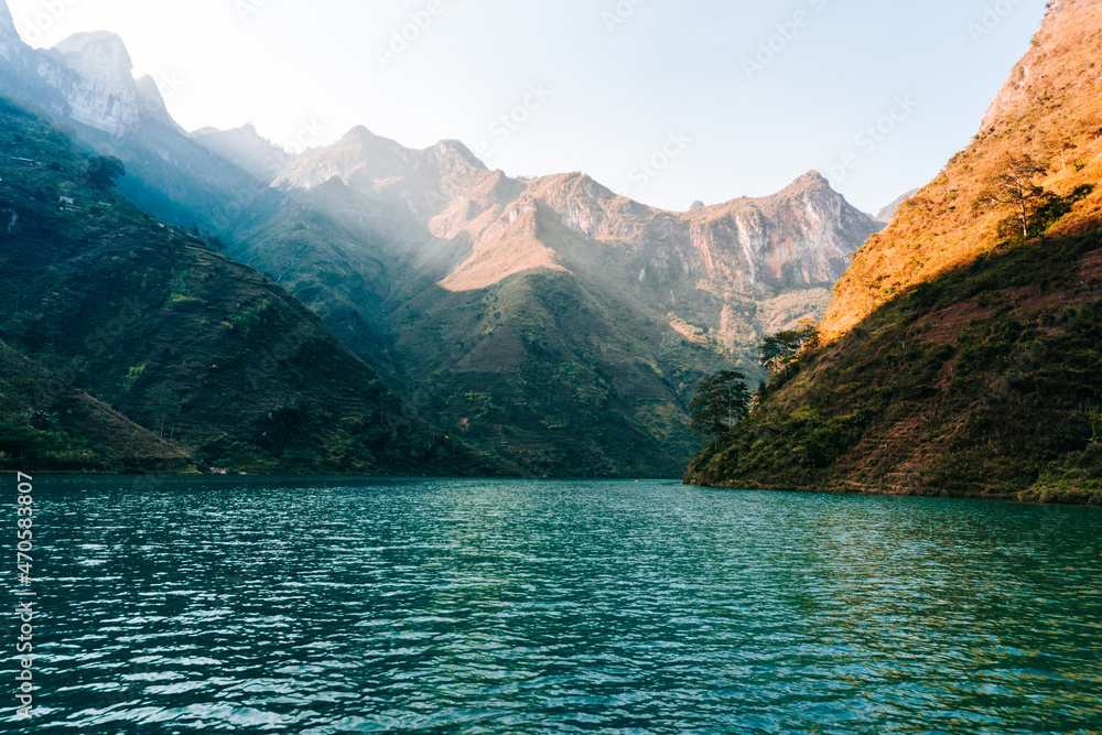 Sunlight shines through the mountains into the river in Ha Giang, Vietnam