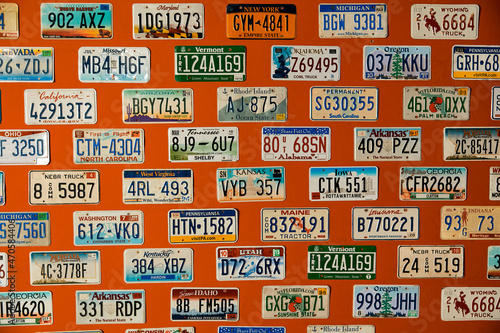 American license plates hang on an orange wall