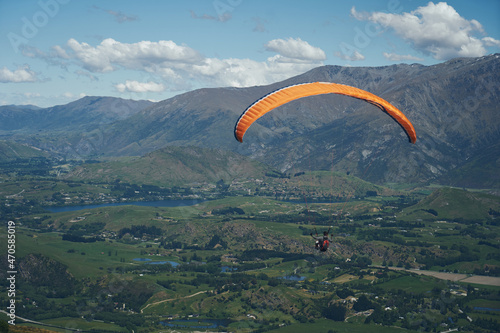 paraglider between the mountains and blue sky relaxing and enjoying the view