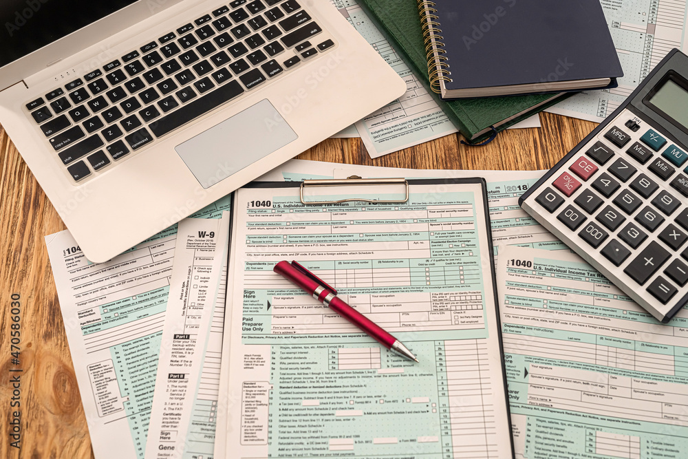 Obraz premium on wooden table are tax forms 1040, calculator, laptop pen notebooks