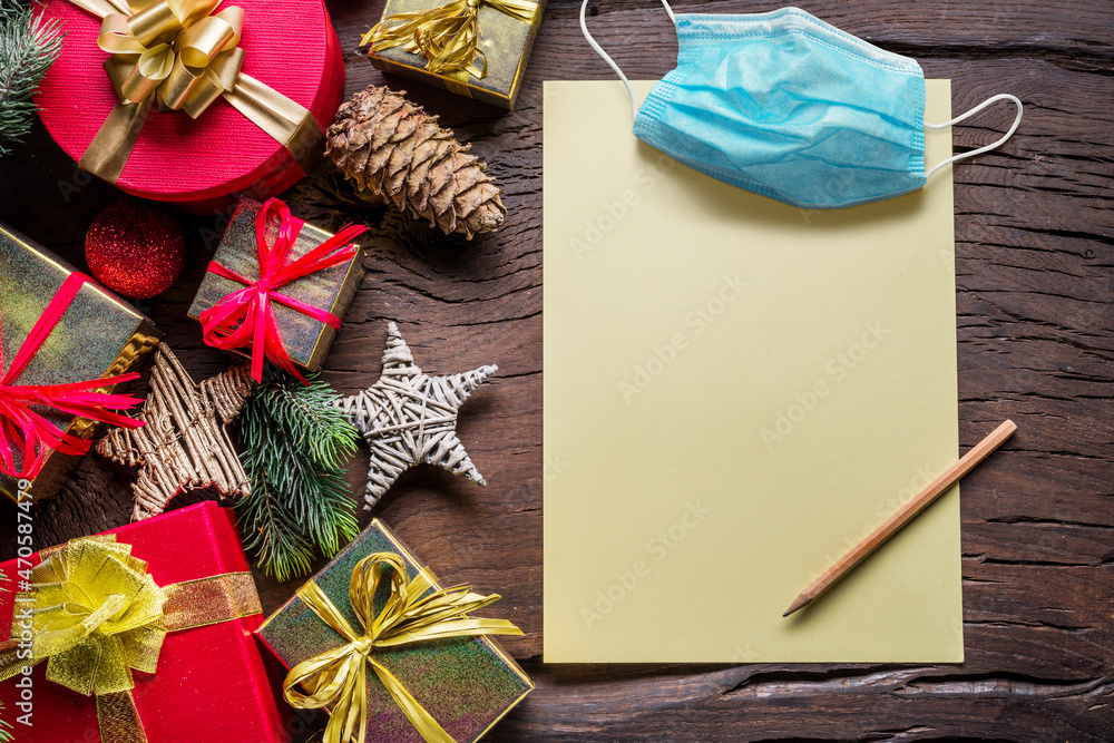 Empty Santa paper letter and Christmas decoration and medical mask around it. Christmas or New Year holiday background of holiday in quarantine. Top view. Empty Santa paper letter and Christmas decoration and medical mask around it. Christmas or New Year holiday background of holiday in quarantine. Top view.