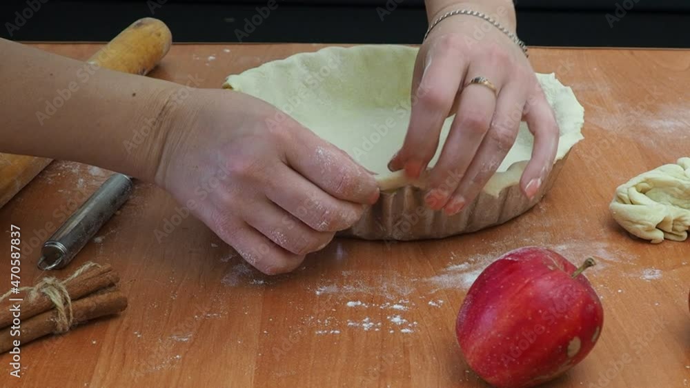 girl prepares apple pie to celebrate thanksgiving or christmas. Ingredients for apple pie cooking. Fresh red apple, butter, flour, brown sugar, nuts and spices on a wooden background. girl prepares apple pie to celebrate thanksgiving or christmas. Ingredients for apple pie cooking. Fresh red apple, butter, flour, brown sugar, nuts and spices on a wooden background.
