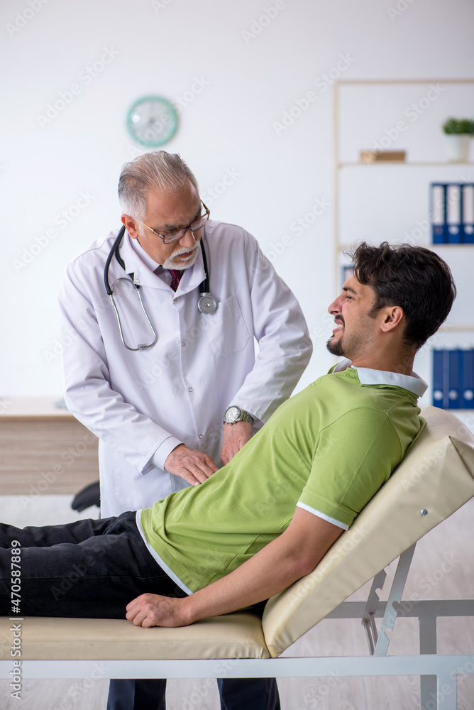 Young male patient visiting old male doctor Young male patient visiting old male doctor