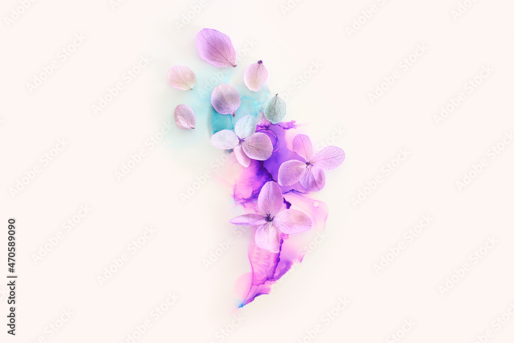 Creative image of pink and purple Hydrangea flowers on artistic ink background. Top view with copy space