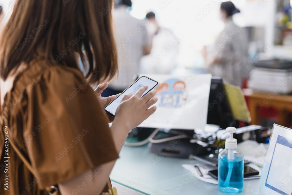 Customer hand scanning qr code for cashless payment at retail shop. Customer hand scanning qr code for cashless payment at retail shop.