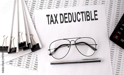 TAX DEDUCTIBLE text on paper with chart and office tools   business concept