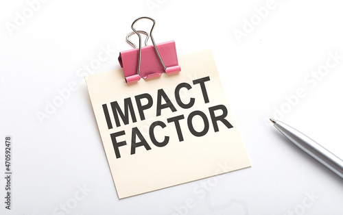 IMPACT FACTOR text on the sticker with pen on the white background