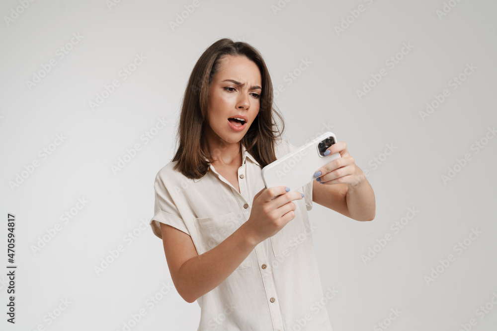 Young european woman playing video game on cellphone Young european woman playing video game on cellphone