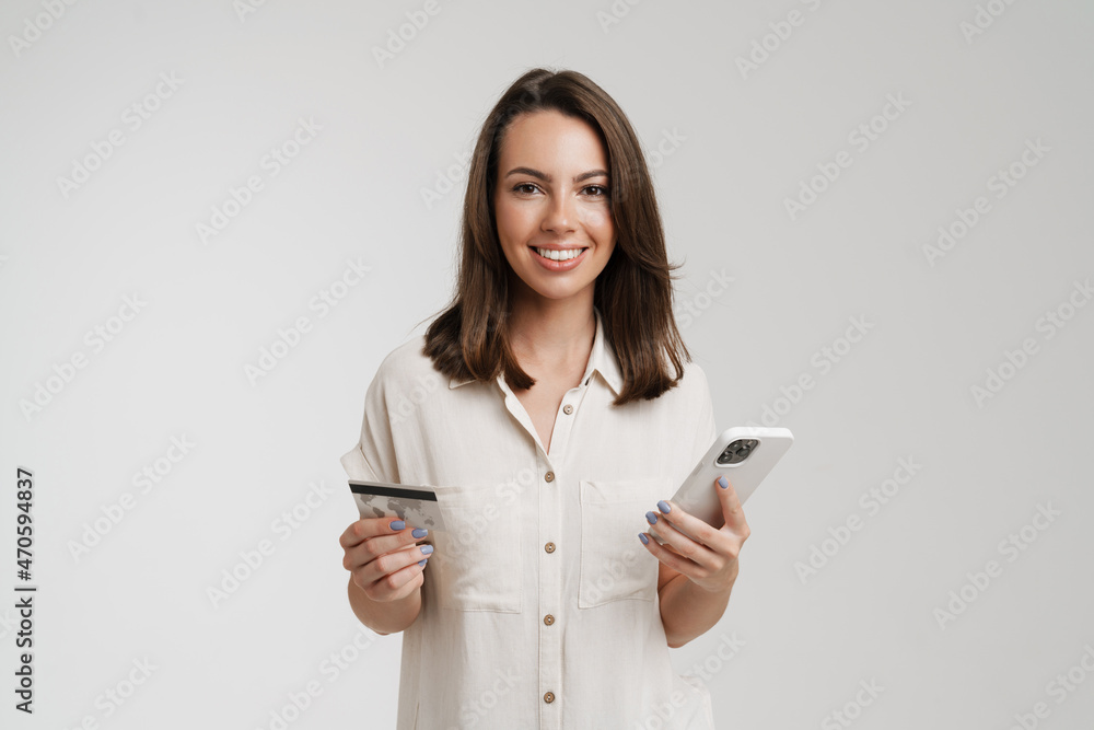 Young european woman posing with mobile phone and credit card Young european woman posing with mobile phone and credit card
