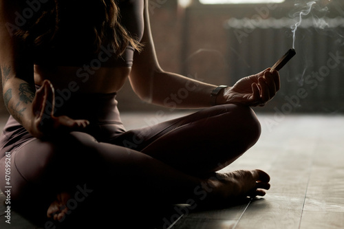 Athlete with burnt sandalwood meditating at yoga studio photo