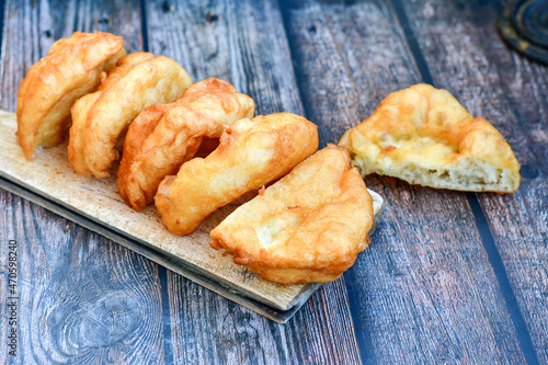 Traditional Bulgarian home made deep fried  patties  covered with sugar  оn rustic backgroud.Mekitsa or Mekica,  on wooden  rustic  background. Made of kneaded dough that is deep fried  photo