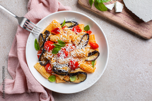 Quadro em tela Italian vegetarian pasta with eggplant, tomato sauce, basil, served with grated ricotta salata cheese in a white plate