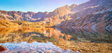 Autumnal Tatra mountains. Crystal water in the lake Big Pond surrounded by mountains in the Valley of Five Lakes (Tatra Mountains National Park). Travel, ecology concepts. Sunset. Poland.