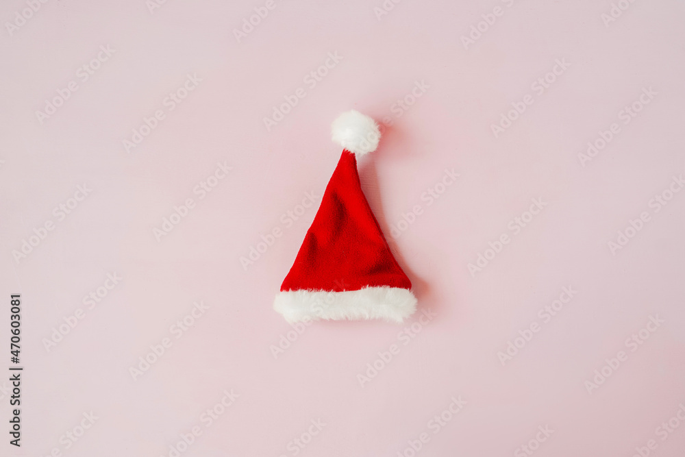 Red Christmas hat on pink background above.