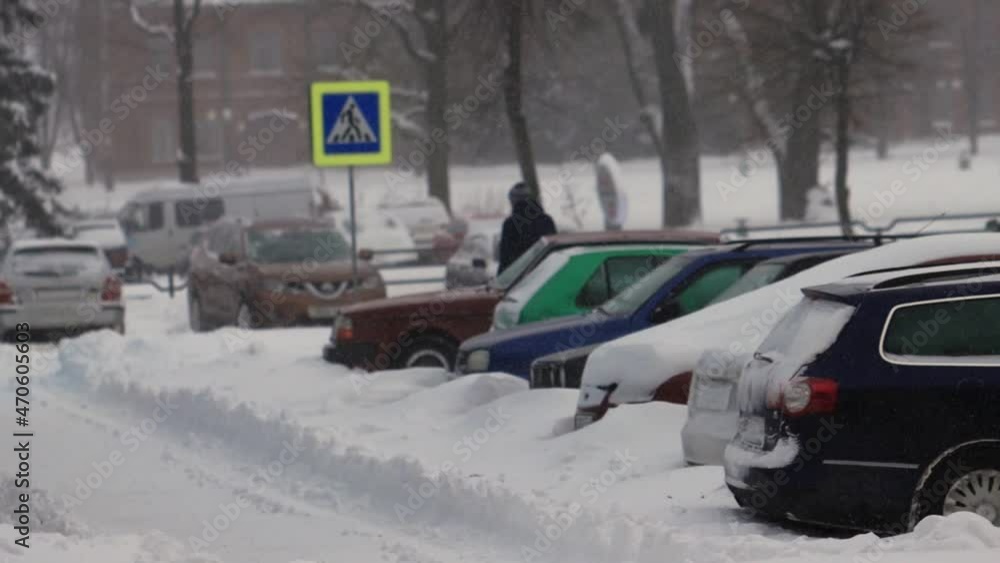 Winter. Parked cars were covered with snow. A strong wind is blowing. Snowfall in slow motion. Bad weather conditions for traffic, blizzard. Danger of road accidents. Crossroad Winter. Parked cars were covered with snow. A strong wind is blowing. Snowfall in slow motion. Bad weather conditions for traffic, blizzard. Danger of road accidents. Crossroad