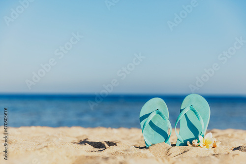 Flip flops stuck in the sand on a sandy beach by the sea or ocean