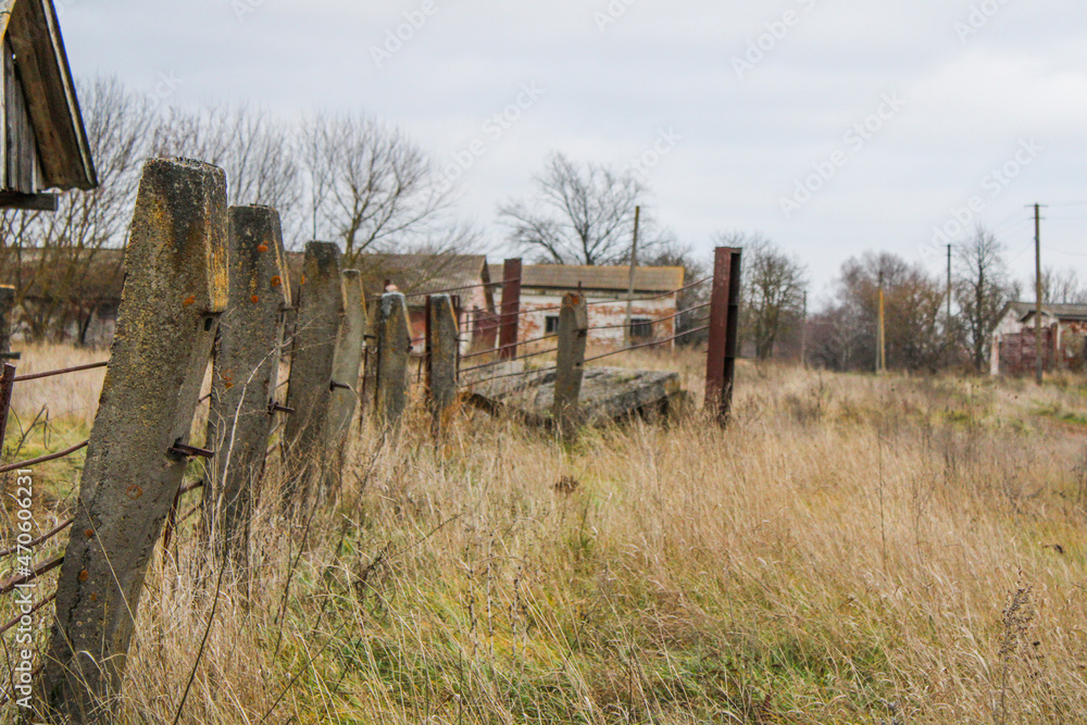 old concrete fence in the field behind the farm