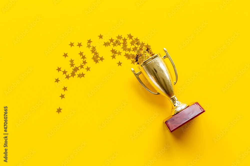 Victory concept with winner golden trophy cup and shiny stars