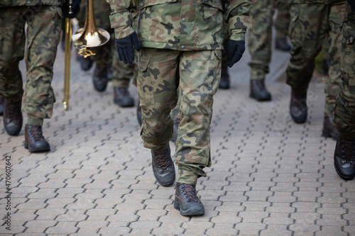Soldiers on parade march with brass instruments.