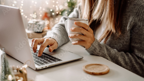 Wallpaper Mural Close up of woman hands with, gifts, coffee cup and laptop. Online shopping at Christmas holidays. Freelance girl woking from home office. Female typing at notebook computer. Christmas moments. Torontodigital.ca