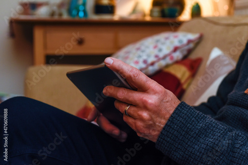 Senior man using tablet device on internet connected by home wifi he is sitting on a sofa © tommoh29