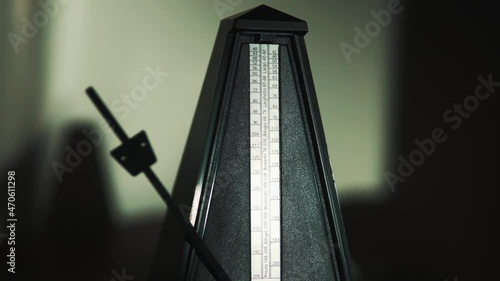 Vintage metronome with golden pendulum beats slow rhythm photo