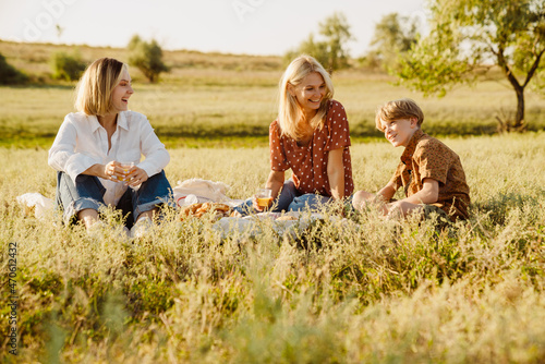 White family laughing during picnic on summer field