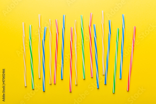 many multi-colored plastic tubes for cocktail on Colored background, top view