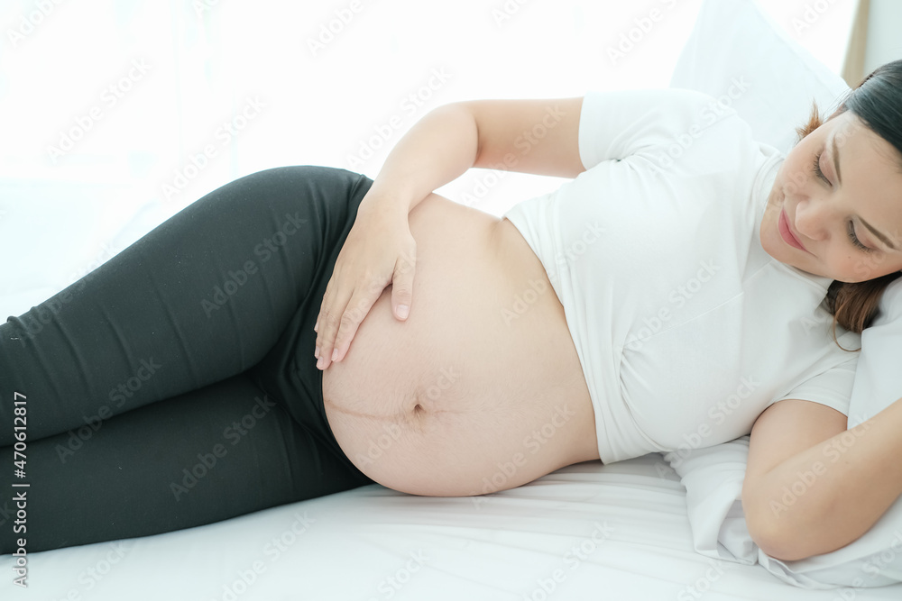 portrait asian young pregnant woman lying on the bed portrait asian young pregnant woman lying on the bed