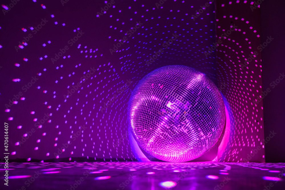Disco ball reflecting violet light in a dark hall for discos. Holidays concept. Copy space. Disco ball reflecting violet light in a dark hall for discos. Holidays concept. Copy space.