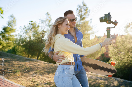 Smiling woman vlogging with man through camera at park photo