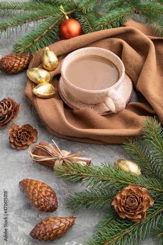 Christmas or New Year composition. Decorations, cones, fir and spruce branches, cup of coffee, on a gray concrete background. Side view.