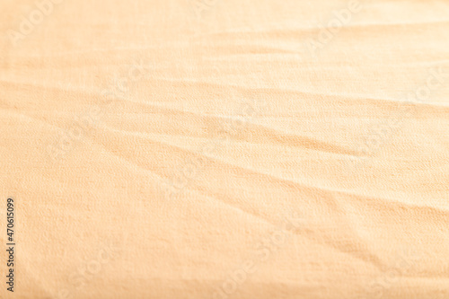 Fragment of smooth orange linen tissue. Side view, natural textile background.