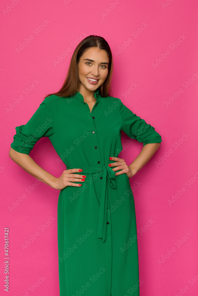 Beautiful smiling woman is posing in long button-up green dress Beautiful smiling woman is posing in long button-up green dress
