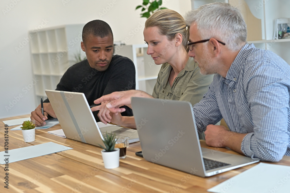 Business people in modern meeting room working together on project Business people in modern meeting room working together on project