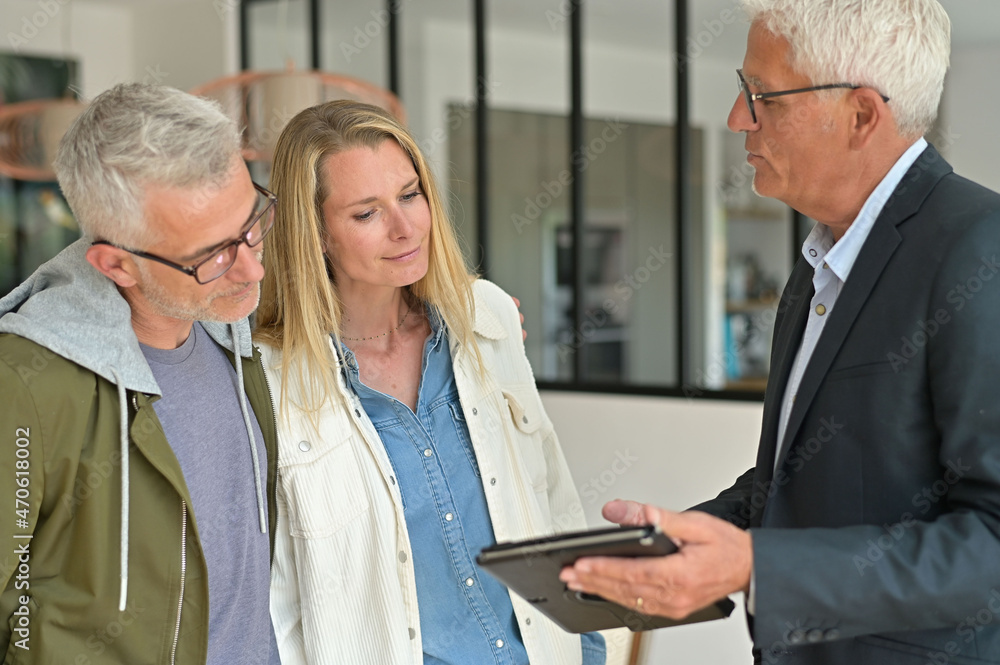 couple signing contract with real estate agent couple signing contract with real estate agent