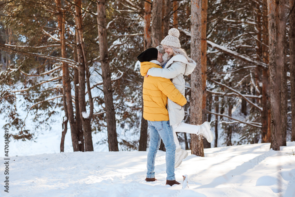 Good-looking couple is having fun in winter forest, spending Christmas holidays outdoors. Good-looking couple is having fun in winter forest, spending Christmas holidays outdoors.