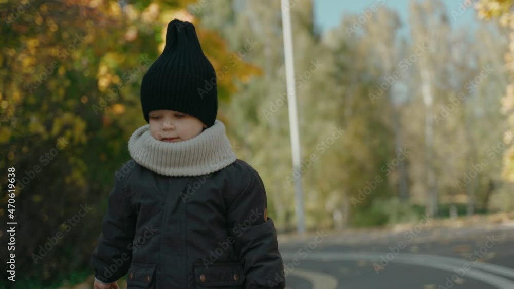 Beautiful baby boy walks to the camera in the fall park on a sunny day. Having fun in the autumn park. High quality 4k footage Beautiful baby boy walks to the camera in the fall park on a sunny day. Having fun in the autumn park. High quality 4k footage
