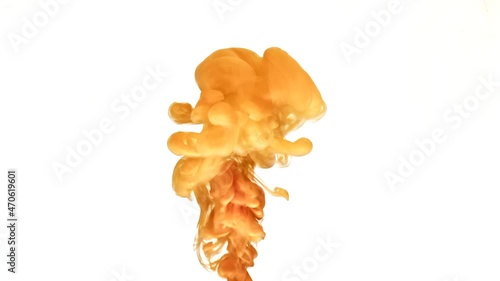 Burst of orange color paint rises in transparent water as decorative abstract background slow motion extreme close view