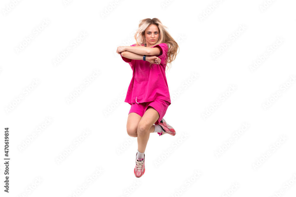 dancing blonde in a pink tracksuit and short shorts on a white background in a jump dancing blonde in a pink tracksuit and short shorts on a white background in a jump