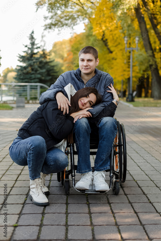Young girlfriend leaning on disabled boyfriend's lap at park Young girlfriend leaning on disabled boyfriend's lap at park