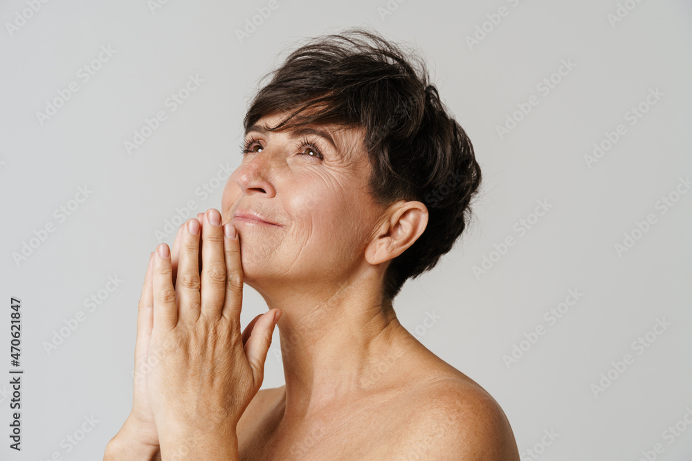 Mature half-naked woman smiling and looking upward Mature half-naked woman smiling and looking upward