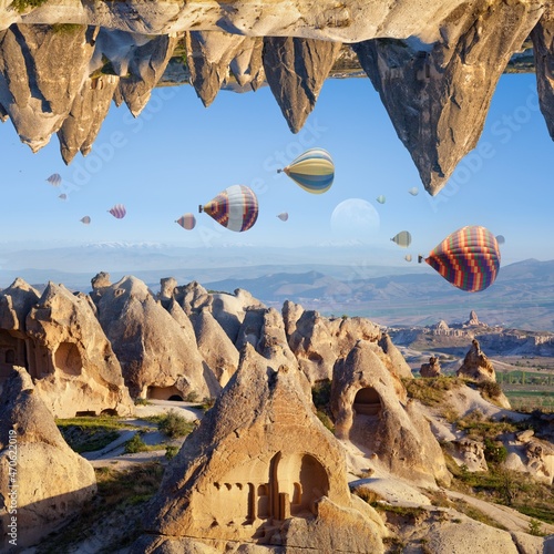 Welcome to Cappadocia concept. Fantastic unreal turned upside down landscape. Hot air balloons fly in clear morning sky near Goreme, Cappadocia, Turkey.