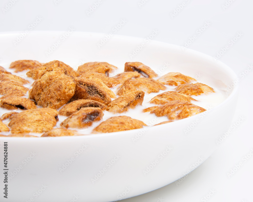 Crispy pads chocolate pillows with milk in dish isolated on the white background Crispy pads chocolate pillows with milk in dish isolated on the white background