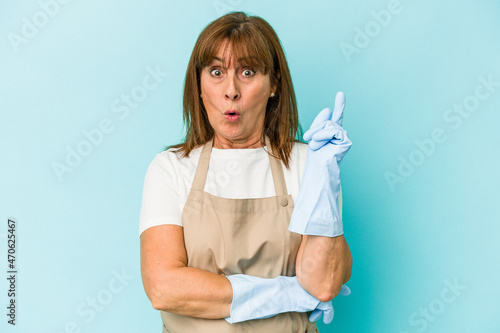 Middle age caucasian woman cleaning home isolated on blue background having some great idea, concept of creativity.